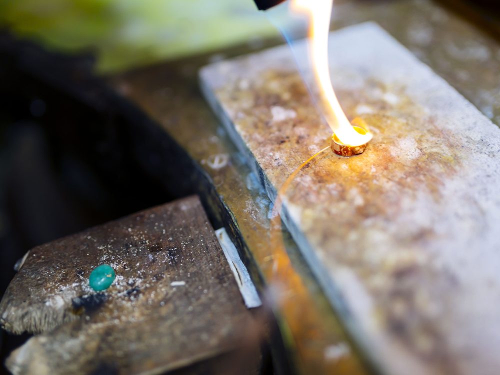 Goldsmith working on a ring with torch